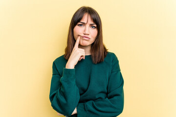 Young caucasian woman isolated on yellow background unhappy looking in camera with sarcastic expression.