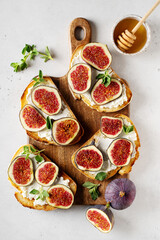Fig bruschetta, bread and cream cheese and fruit on white background