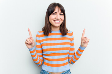 Young caucasian woman isolated on white background indicates with both fore fingers up showing a...