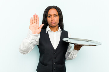 Young African American waitress woman holding a tray isolated on blue background standing with...