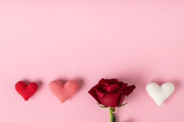 A red rose and three hearts on a pink background. Banner for Valentine's Day. A postcard for...