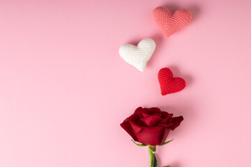 A red rose and three hearts on a pink background. Banner for Valentine's Day. Postcard for February...