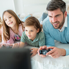 Family spending time together in bedroom, playing games, and playing with their dog