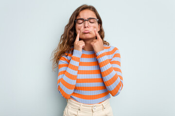 Young caucasian woman isolated on blue background crying, unhappy with something, agony and confusion concept.