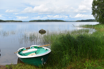 Naklejka na ściany i meble fishing boat on water. rural peaceful landscape. fisherman's boat on the lake