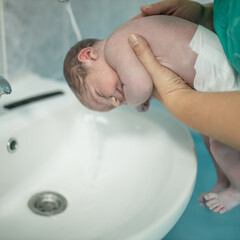 Original footage of newborn baby after labor, doctor examining her.