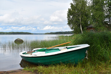 Fototapeta na wymiar fishing boat on water. rural peaceful landscape. fisherman's boat on the lake