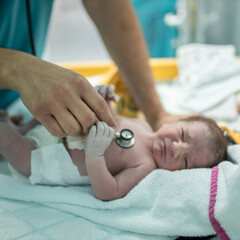 Obraz na płótnie Canvas Original footage of newborn baby after labor, doctor examining her.