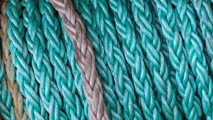 Turquoise ship mooring rope on a reel close-up.