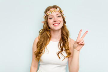 Young elf woman isolated on blue background joyful and carefree showing a peace symbol with fingers.