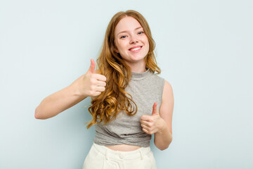 Young caucasian woman isolated on blue background raising both thumbs up, smiling and confident.