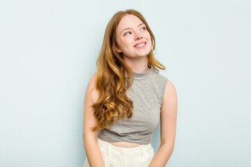 Fototapeta premium Young caucasian woman isolated on blue background relaxed and happy laughing, neck stretched showing teeth.