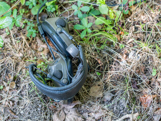 British army warrior soldier headset and microphone with comms cable attached, laying on dry ground 