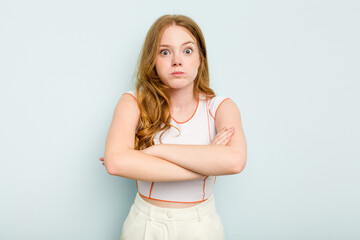 Young caucasian woman isolated on blue background shrugs shoulders and open eyes confused.