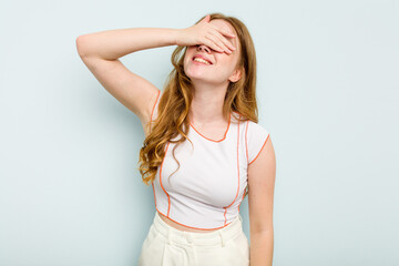 Young caucasian woman isolated on blue background laughs joyfully keeping hands on head. Happiness concept.