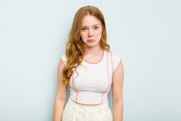 Young caucasian woman isolated on blue background sad, serious face, feeling miserable and displeased.