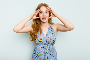 Young caucasian woman isolated on blue background receiving a pleasant surprise, excited and...