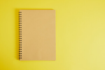 spiral sketchbook with brown kraft sheets on yellow background