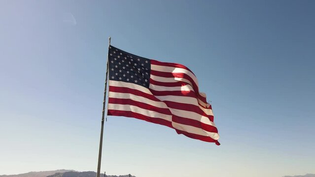 American Flag Blowing in Wind, Blue Sky Background