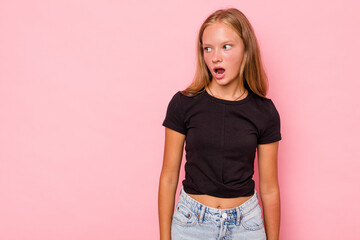 Caucasian teen girl isolated on pink background being shocked because of something she has seen.