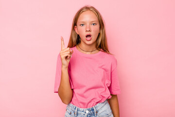 Caucasian teen girl isolated on pink background pointing upside with opened mouth.