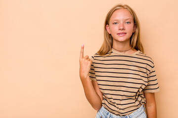 Obraz premium Caucasian teen girl isolated on beige background showing number one with finger.