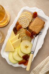 Charcutierie plate with salted, crip cookies crackers, cheese and apples slices. Party or snack food.