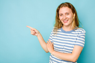 Young caucasian woman isolated on blue background smiling cheerfully pointing with forefinger away.