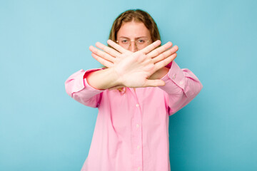 Young caucasian woman isolated on blue background doing a denial gesture