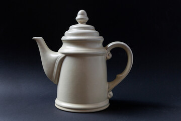 White porcelain teapot on a black background.