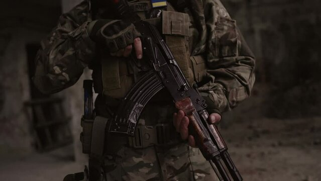 In close-up, a Marine cocks the bolt on his rifle.