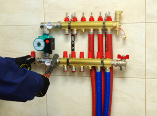 Plumber installing collector and plastic pipes - obrazy, fototapety, plakaty