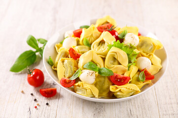bowl of tortellini pasta with tomato,  mozzarella and basil- italian cuisine