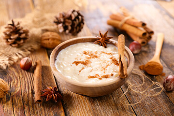 Fototapeta na wymiar rice pudding with spices on wood background