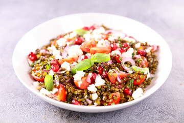 bowl of lentils salad with feta,  tomato and pomegranate