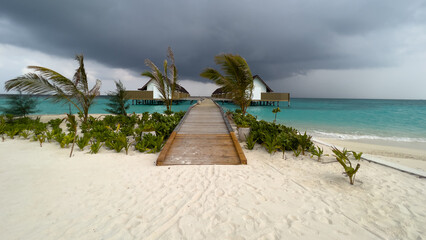 Panoramic view of a wooden jetty leading to the villas