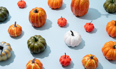 pattern of colorful artificial pumpkins on blue background