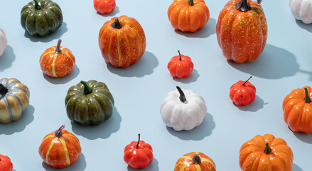 pattern of colorful artificial pumpkins on blue background