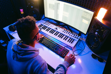 Producer, audio engineer uses a control panel and screen to record a track of a new album in a...