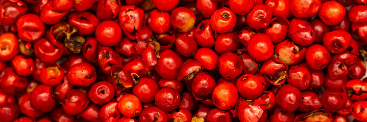 Pink peppercorns, spice close-up flat lay on a white background. Indian and Arabic spices for cooking. Medicinal herbs and spices.