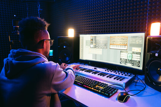 Producer, audio engineer uses a control panel and screen to record a track of a new album in a recording studio, in a soundproof room. Image producer, designer in working process