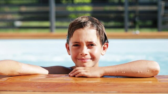 4k video Portrait of handsome boy in sunglasses in swimming pool, child enjoying swimming in summer in pool. Vacation hotel concept.