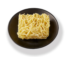 Uncooked square instant noodles are placed on a black plate isolated on white background.