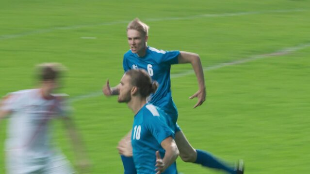 Soccer Football Championship Match: Blue Team Players Attack, Kick the Ball, Goalkeeper Misses the Goal. Portrait of Forward. Sport Channel Broadcast Television Playback. Fast Tracking Shot