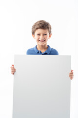 Funny child showing a white advertising poster with space for text.
