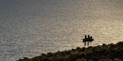 Men standing on the ship in the water during the evening