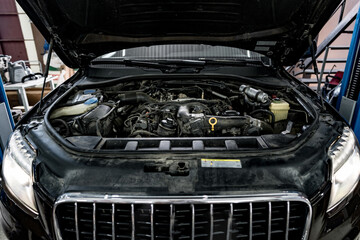 View of engine and other parts under the open hood of a car