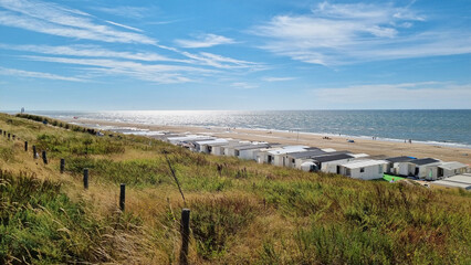 View from dunes on North Sea city beach on a sunny summer weekend. Typical pavilions. Zandvoort, Netherlands - obrazy, fototapety, plakaty