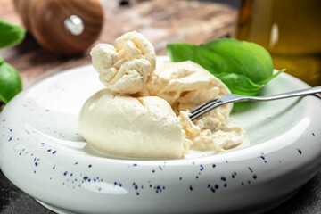 fresh soft white burrata cheese ball made from mozzarella and cream from Apulia, Italian Mediterranean cuisine, Food recipe background. Close up