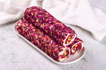 Turkish delight with pistachio on a gray background. Turkish delight covered with rose petals....